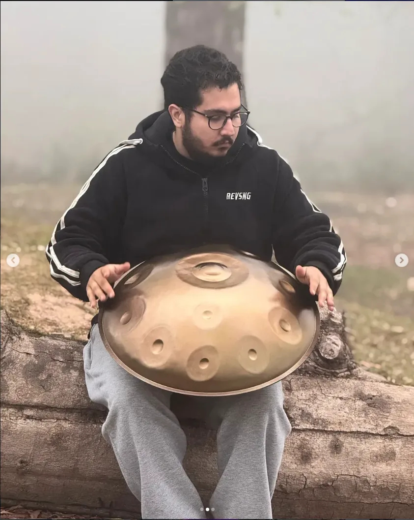 Arman Soltani playing handpan outdoors.