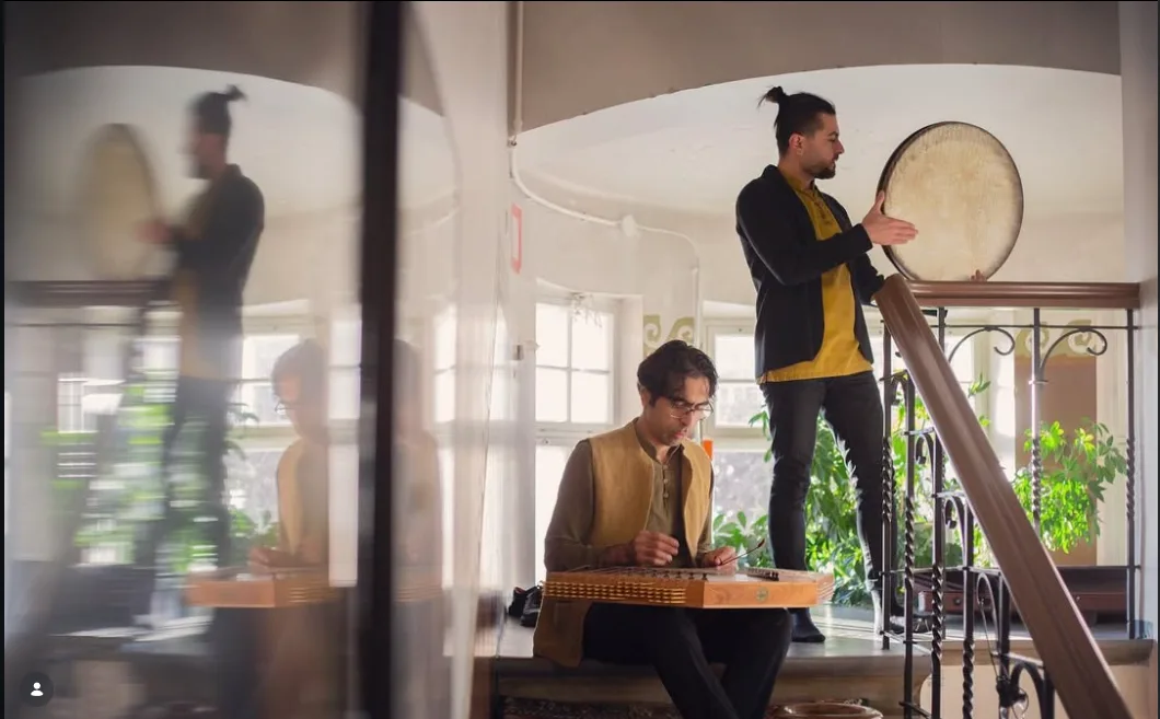 Farshad Sanati with a daf musician on a staircase.