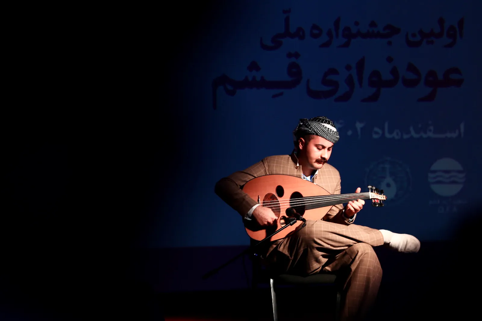 Ismail Kalaki performing Oud on stage.