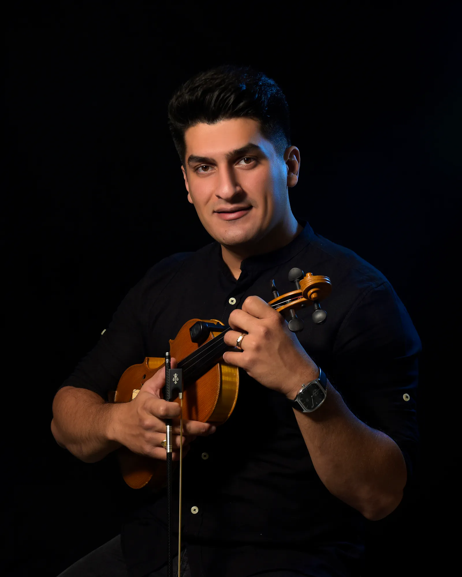 Kasra Kaveh holding his violin.