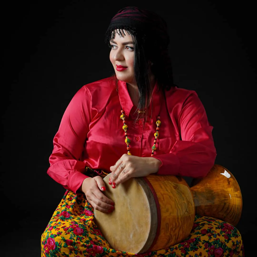 Leila Azimi with a Kurdish Zarb in a studio portrait.