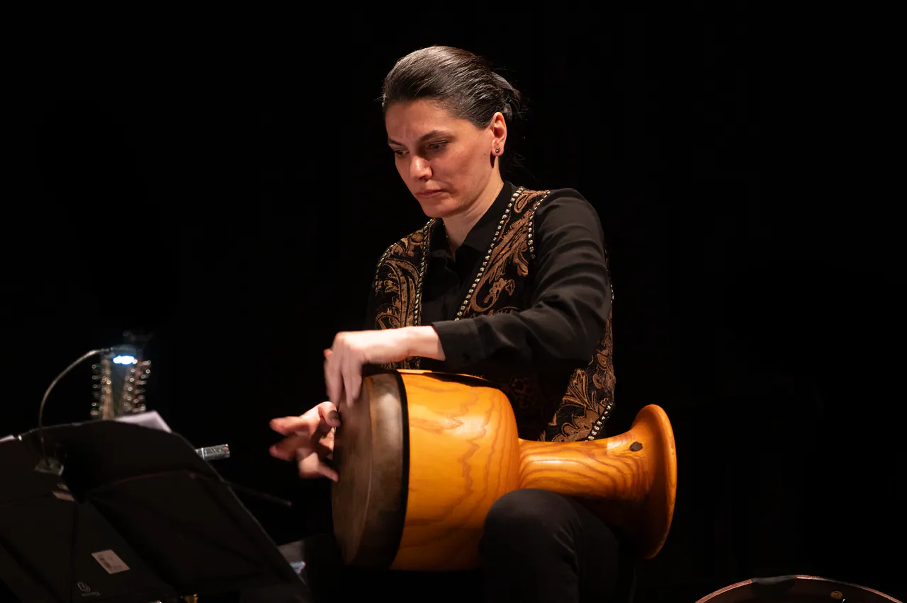 Sara Fotros playing percussion during a live concert.