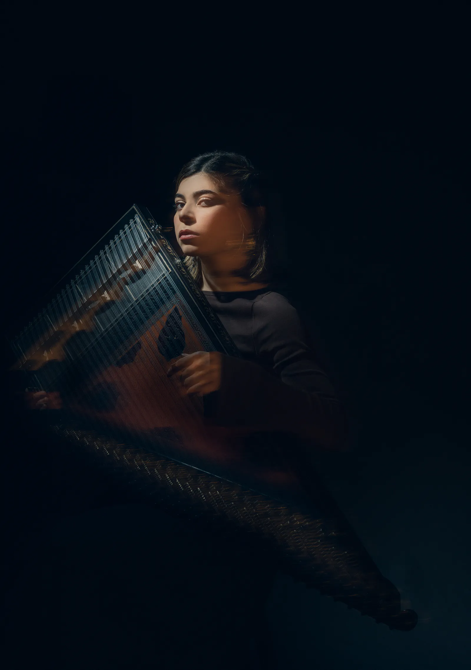 Sara Majidinejad holding a Qanun in an editorial portrait.