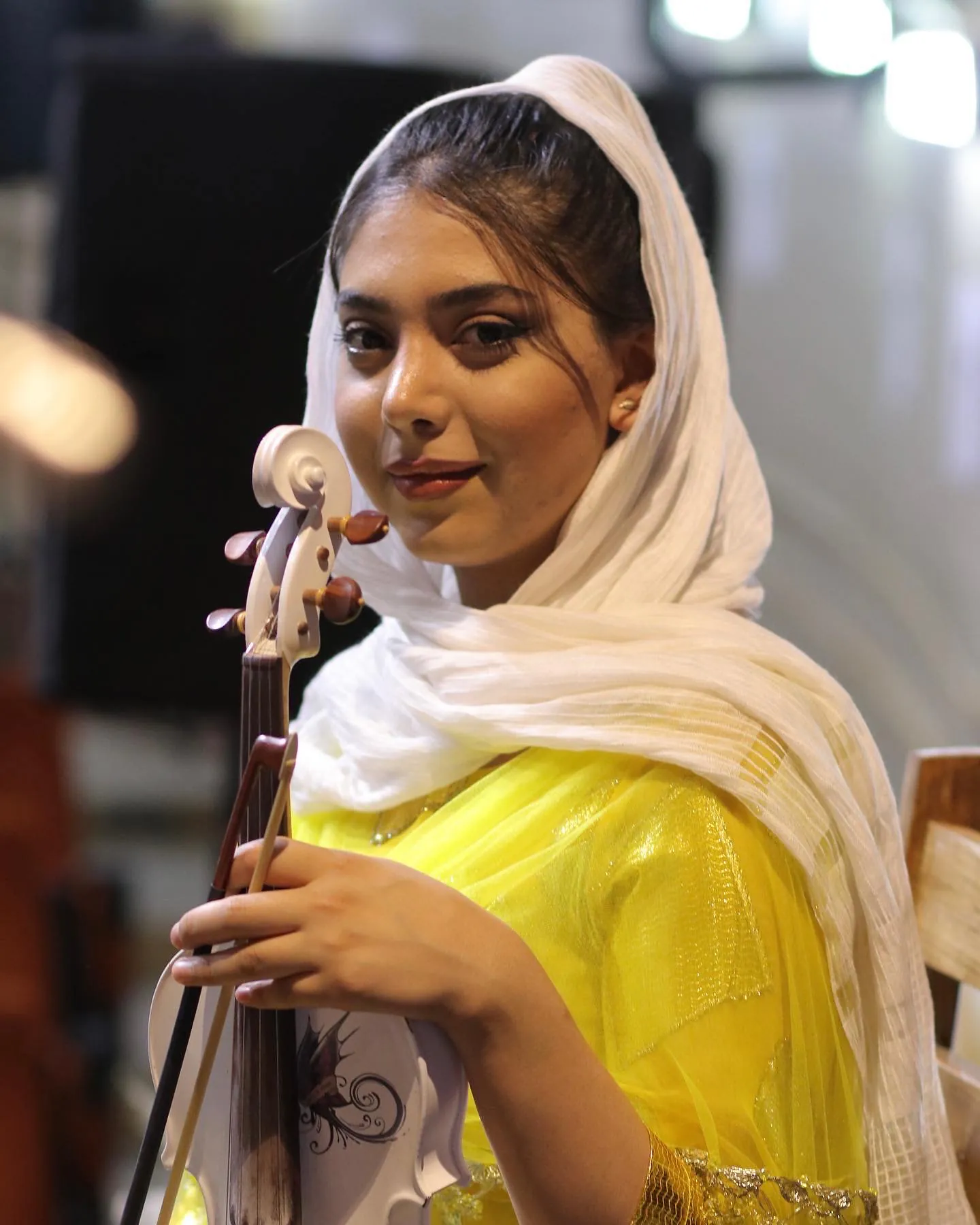 Shno Sharifzadeh holding her violin.